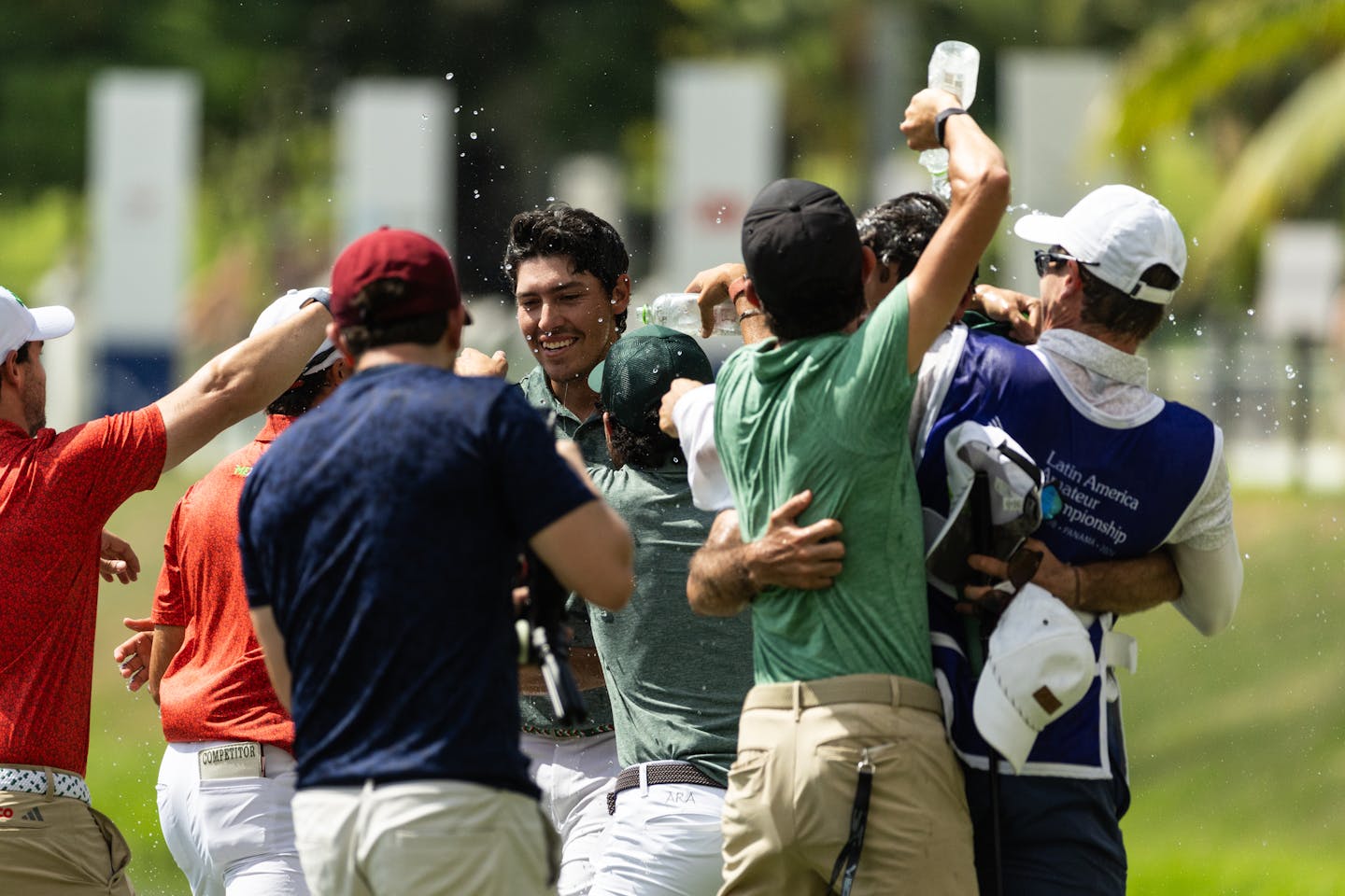 Santiago de la Fuente (C) of Mexico is doused by friends and players after winning on the No. 18 green.